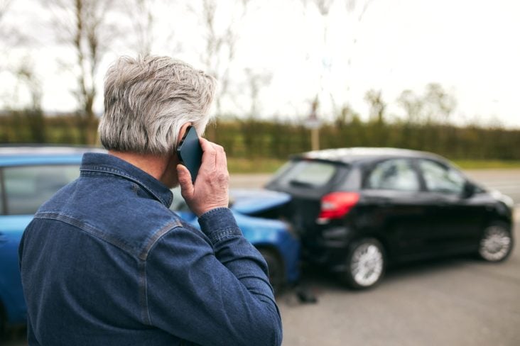 homem utiliza telefone após acidente batida de carro