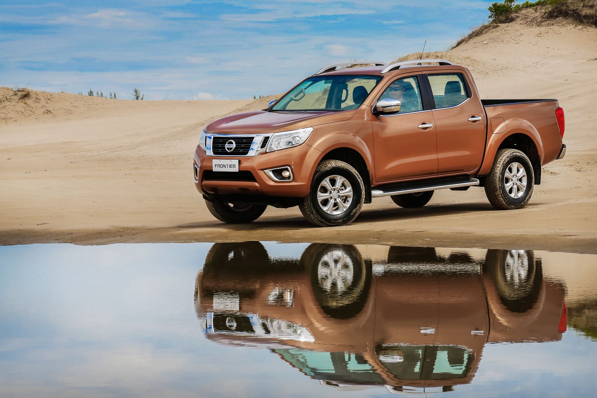 nissan frontier double cab laranja frente parada em duna